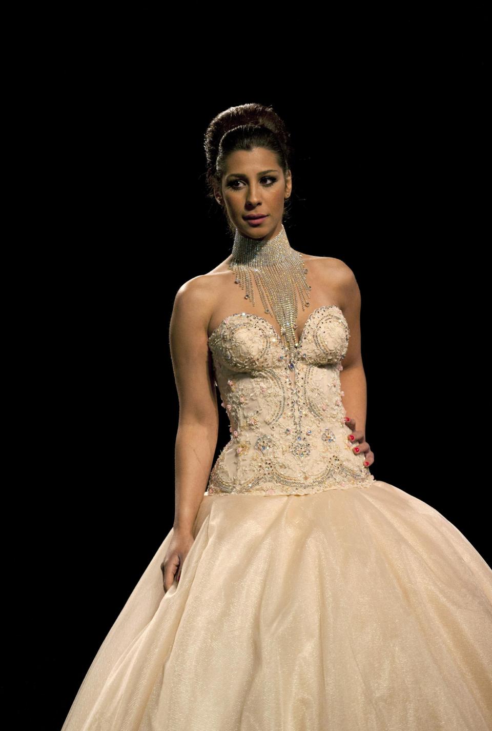 In this photo taken Friday, May 2, 2014, a model displays a creation by designer Fayzeh Pearl during the second day of the Palestine Fashion Week 2014, in the West Bank city of Ramallah. The three-day show, which ended Saturday, May 3, 2014, saw models prowl the catwalk in the only major fashion show in the Palestinian territories. (AP Photo/Nasser Nasser)