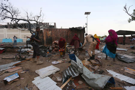 Somali women and security forces search through the damage caused at the scene of a blast near the Mogadishu sea port in Mogadishu, Somalia, May 24, 2017. REUTERS/Feisal Omar