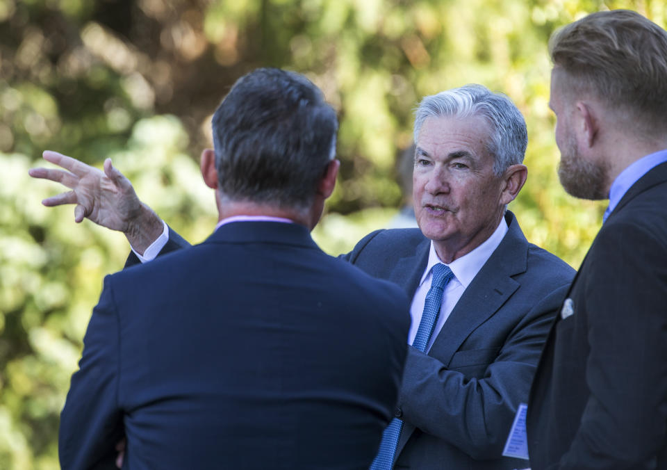 File - Federal Reserve Chair Jerome Powell, center, talks with attendees of the central bank's annual symposium at Jackson Lake Lodge in Grand Teton National Park, Aug. 26, 2022. in Moran, Wyo. As Powell returns to Jackson Hole this week, the U.S. economy's resilience has raised the prospect that the Fed will need to keep its key rate higher for longer than had been expected. (AP Photo/Amber Baesler, File)