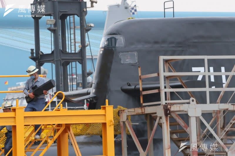 <cite>海鯤號潛艦26日由海昌廠移至中信八號浮動船塢，現場人員手持無人機干擾槍警戒。（顏麟宇攝）</cite>