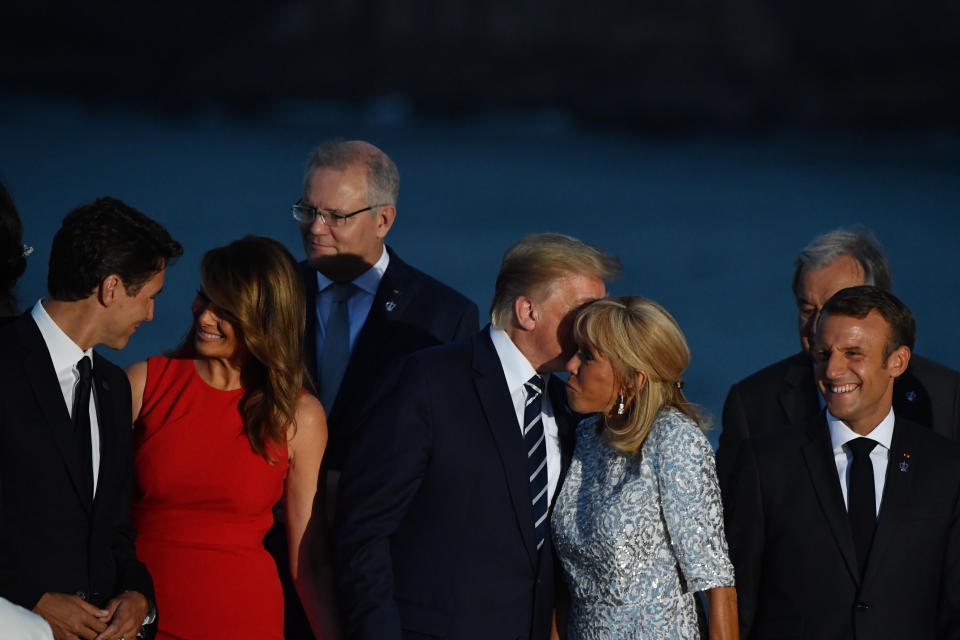 Scott Morrison stands back while the partners of world leaders, including Justin Trudeau and Donald Trump, come up on the podium for a photo. Source: AAP Image