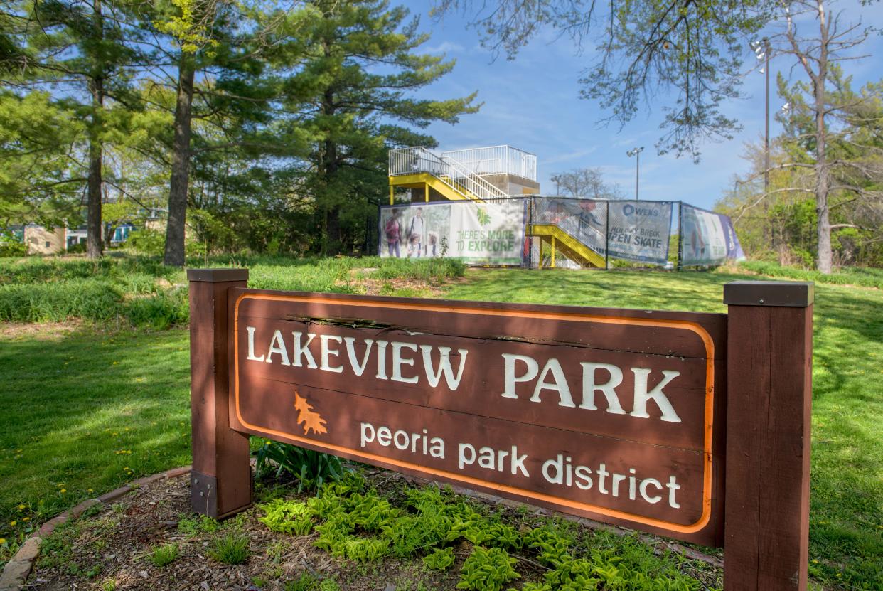 The stairway to a water slide at the abandoned Lakeview Aquatic Center stands in the background behind a sign at the entrance to Lakeview off Lake Avenue in Peoria.