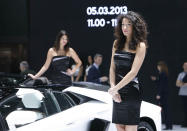 Lamborghini booth models pose for cameras at the 2013 Geneva Motor Show.