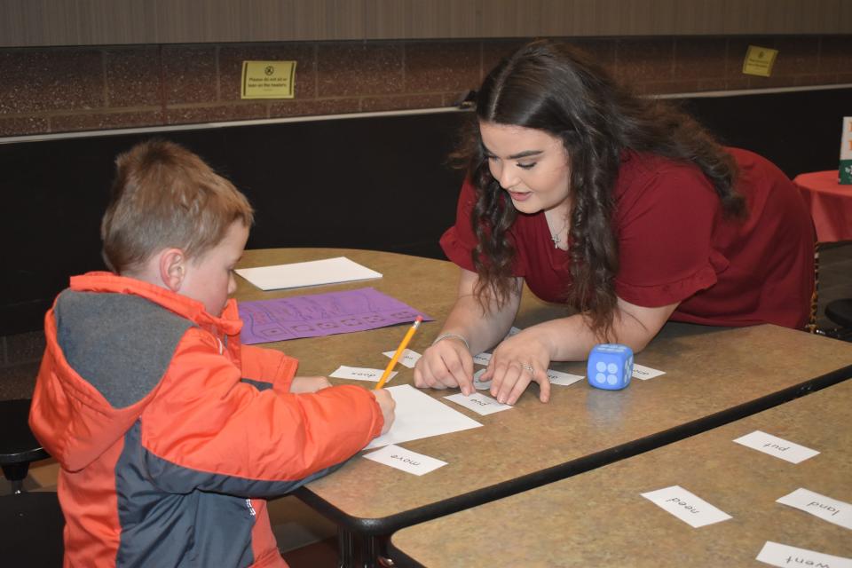 Bryce Bailey, a Young 5's student at Addison Community Schools, works with Adrian College elementary teacher education student Kayla Doney on spelling three- and four-letter words during a literacy night program Tuesday at Addison Middle/High School. Bailey's older brother, Lucas, a third grader at Addison, also was a participant during the literacy night event, which was conducted by 15 Adrian College teacher education students.