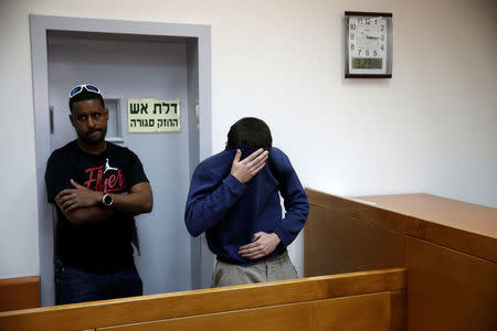 U.S.-Israeli teen (R) arrested in Israel on suspicion of making bomb threats against Jewish community centres in the United States, Australia and New Zealand over the past three months, is seen before the start of a remand hearing at Magistrate's Court in Rishon Lezion, Israel March 23, 2017. REUTERS/Baz Ratner
