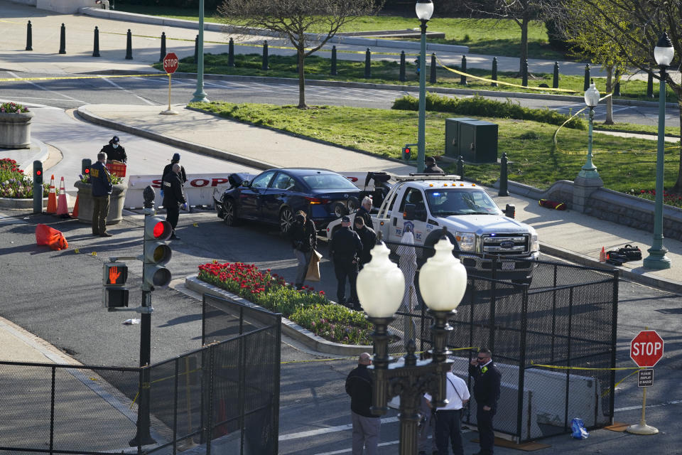 Authorities investigate the scene after a man rammed a car into two officers at the barricade on Capitol Hill in Washington, Friday, April 2, 2021. (AP Photo/Alex Brandon)