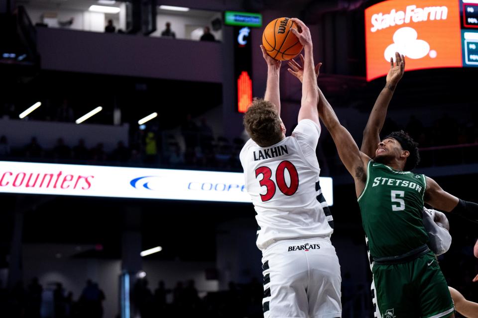 Cincinnati Bearcats forward Viktor Lakhin (30) grabs a rebound over Stetson Hatters guard Jalen Blackmon (5). Lakhin finished with 12 points and nine rebounds in UC's 83-75 win.