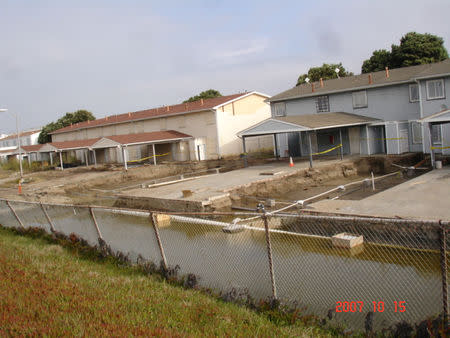 Treasure Island residents remained living in 1325 Westside Drive (blue building at right) while workers cleaned up environmental contamination in front of the home in Treasure Island, near San Francisco, California, U.S., in this October 2007 handout photo. Handout via REUTERS