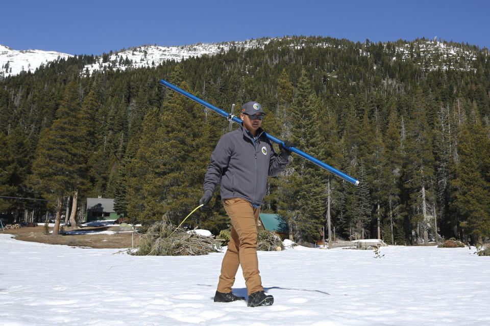 Sean de Guzman, chief of snow surveys for the California Department of Water Resources, carries the snowpack measuring tube as he conducts during the third snow survey of the season at Phillips Station near Echo Summit, Calif., Thursday, Feb. 27, 2020. The survey found the snowpack at 29 inches deep with a water content of 11.5 inches at this location. February is shaping up to be the driest on record for much of the state. (AP Photo/Rich Pedroncelli)