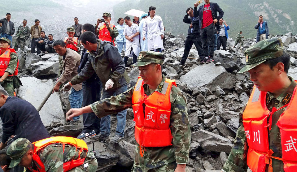 <p>Emergency personnel and local people work at the site of a landslide in Xinmo village in Maoxian County in southwestern China’s Sichuan Province, Saturday, June 24, 2017. (Photo: Chinatopix via AP) </p>