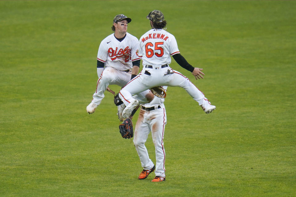 Baltimore Orioles left fielder Austin Hays, left, right fielder Ryan McKenna, right, and center fielder Cedric Mullins celebrate after defeating the New York Yankees 10-6 during a baseball game, Sunday, May 16, 2021, in Baltimore. (AP Photo/Julio Cortez)