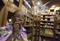 Staff member Maria Regla, 60, smokes a hand-rolled cigar at a hotel in Havana December 19, 2014. REUTERS/Enrique De La Osa