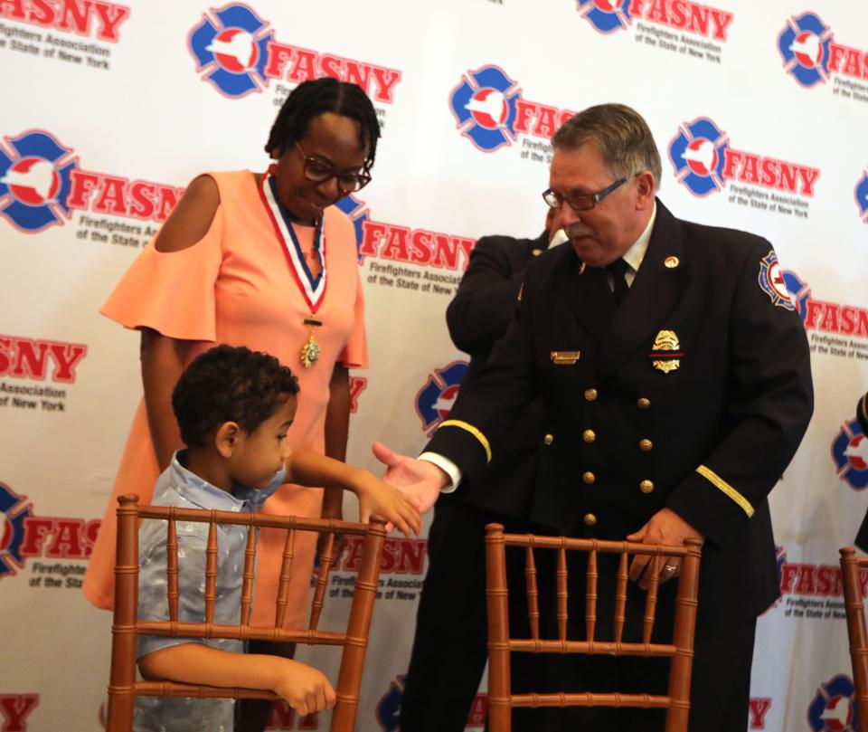 Sabrail Davenport, the mother of Jared Lloyd, the Spring Valley firefighter who died in the line of duty in 2021, and LloydÕs son Darius, 5, took part in a ceremony in which Jared Lloyd was posthumously honored as the firefighter of the year during the Firefighters Association of New YorkÕs 150th annual convention at the Tarrytown House Estate Aug. 10 2022. Lloyd died March 23, 2021 as he tried to rescue residents in a massive fire at Evergreen Court Home For Adults in Spring Valley.