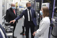 French President Emmanuel Macron, center, wearing a protective face mask, listens to explanations by an employee as CEO of France-based multinational automotive supplier Valeo Jacques Aschenbroicha looks on, in Etaples, , northern France, Tuesday May 26, 2020. Emmanuel Macron announced a 8 billion euro ($8.8 billion) plan to save the country's car industry from huge losses wrought by virus lockdowns, including a big boost for electric vehicles. The plan includes government subsidies for car buyers and longer-term investment in innovative technology, especially in battery-powered cars. (Ludovic Marin, Pool via AP)