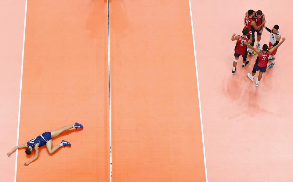 <p>Simone Giannelli of Italy (L) lies on the ground looking dejected as the United States celebrate a point during the Men’s Volleyball Semifinal match on Day 14 of the Rio 2016 Olympic Games at the Maracanazinho on August 19, 2016 in Rio de Janeiro, Brazil. (Photo by Buda Mendes/Getty Images) </p>