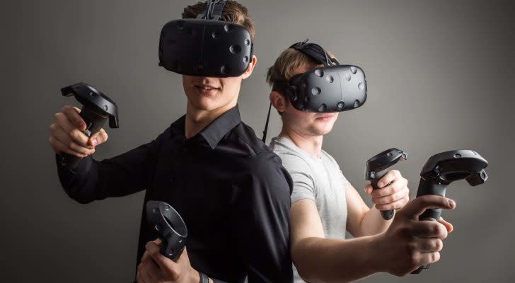 IMMR stock: two people using virtual reality (VR) headsets 