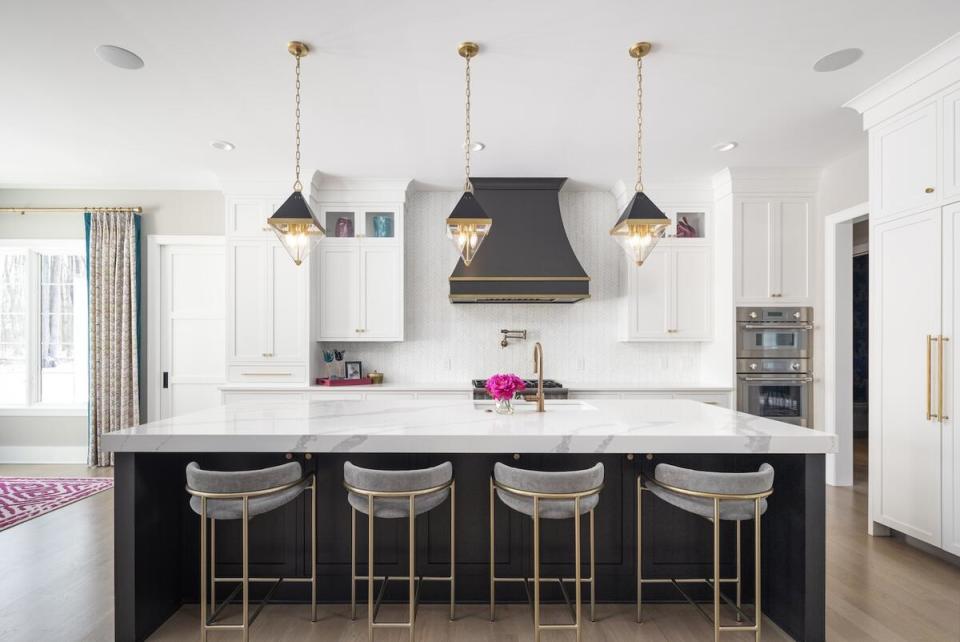 A crisp kitchen glimmers with brass accents