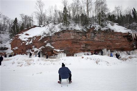 A man rests on frozen Lake Superior, the world's largest freshwater lake, at the sea caves of the Apostle Islands National Lakeshore near Cornucopia, Wisconsin February 15, 2014. REUTERS/Eric Miller