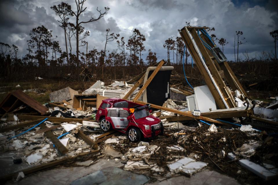 A toy fire engine sits in the rubble of a house destroyed by Hurricane Dorian in Gold Rock Creek, Grand Bahama, Bahamas, Thursday Sept. 12, 2019. Nearly two weeks after Hurricane Dorian hit the northern Bahamas, people continue to scan social media, peer under rubble or follow the smell of death in an attempt to find family and friends. (AP Photo/Ramon Espinosa)