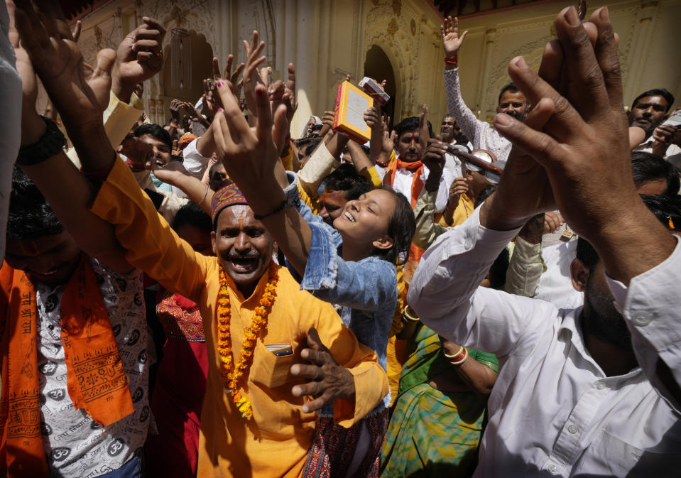 Devotees sing and dance as they celebrate Ramnavi festival, the birthday of Hindu god Ram, in Ayodhya, India, March 30, 2023. India is on the cusp to eclipse China as the world's most populated country, but its religious fault lines have become starker, a testament to the perils of rising Hindu nationalism in a constitutionally secular country. (AP Photo/Manish Swarup)