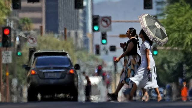 Heat ripples engulf two ladies while crossing the street.