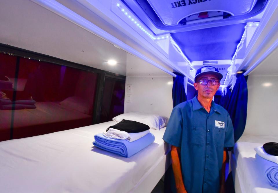 J.R. Gonzalez, head of maintenance with The Source, stands alongside sleeping pods inside the Dignity Bus.