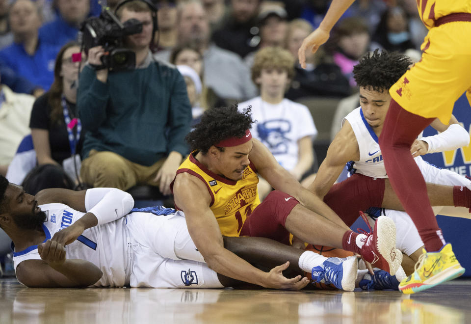 Iowa State's Robert Jones (12), center, scrambles for a loose ball against Creighton's KeyShawn Feazell (1), left, and Ryan Nembhard (2) during the first half of an NCAA college basketball game Saturday, Dec. 4, 2021, at CHI Health Center in Omaha, Neb. (AP Photo/Rebecca S. Gratz)