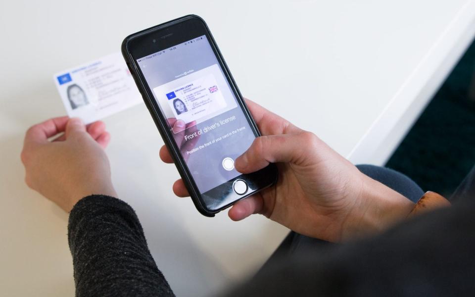 A woman scanning her driver's license through her smartphone  - Onfido