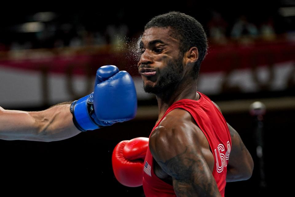 <p>USA's Delante Marquis Johnson (red) takes a punch from Argentina's Brian Agustin Arregui during their men's welter (63-69kg) preliminaries boxing match during the Tokyo 2020 Olympic Games at the Kokugikan Arena in Tokyo on July 24, 2021. (Photo by Frank Franklin II / POOL / AFP) (Photo by FRANK FRANKLIN II/POOL/AFP via Getty Images)</p> 