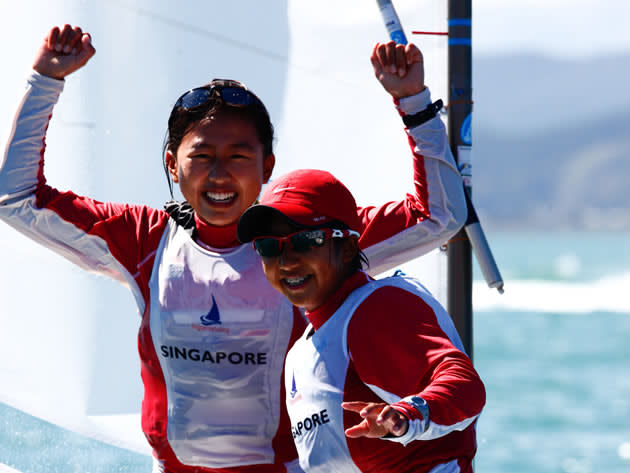 Kimberly Lim celebrates her victory with teammate Elisa Yukie Yokoyama at the 2011 Optimist World Championships in Napier, New Zealand. (Photo: Matias Capizzano)