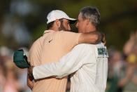 Scottie Scheffler celebrates his win with his caddie Ted Scott at the Masters golf tournament at Augusta National Golf Club Sunday, April 14, 2024, in Augusta, Ga. (AP Photo/Charlie Riedel)