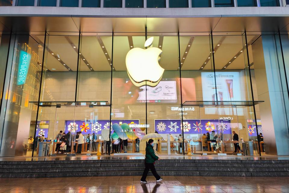 citizens pass an Apple store on Nanjing Road Pedestrian street in Shanghai, China, December 16, 2022