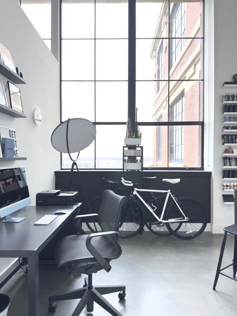 Office area with black desk and bikes.