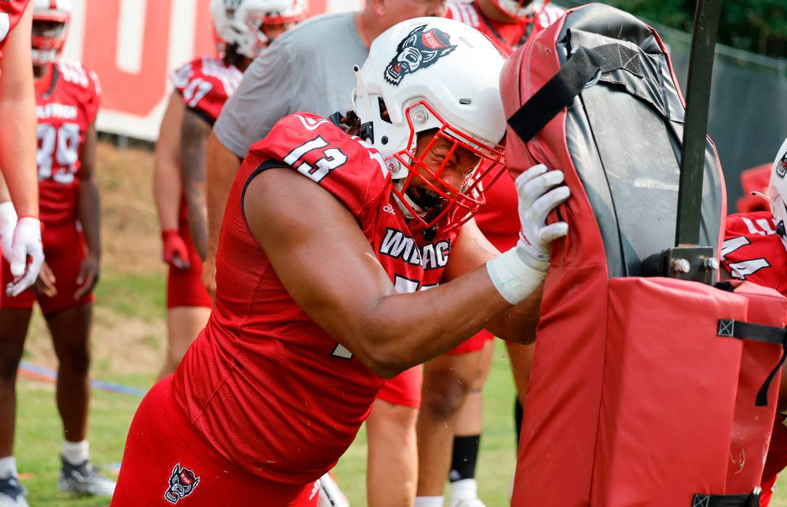 N.C. State defensive end Travali Price (13) attacks the pads during the Wolfpack’s first fall practice in Raleigh, N.C., Wednesday, August 2, 2023. Ethan Hyman/ehyman@newsobserver.com