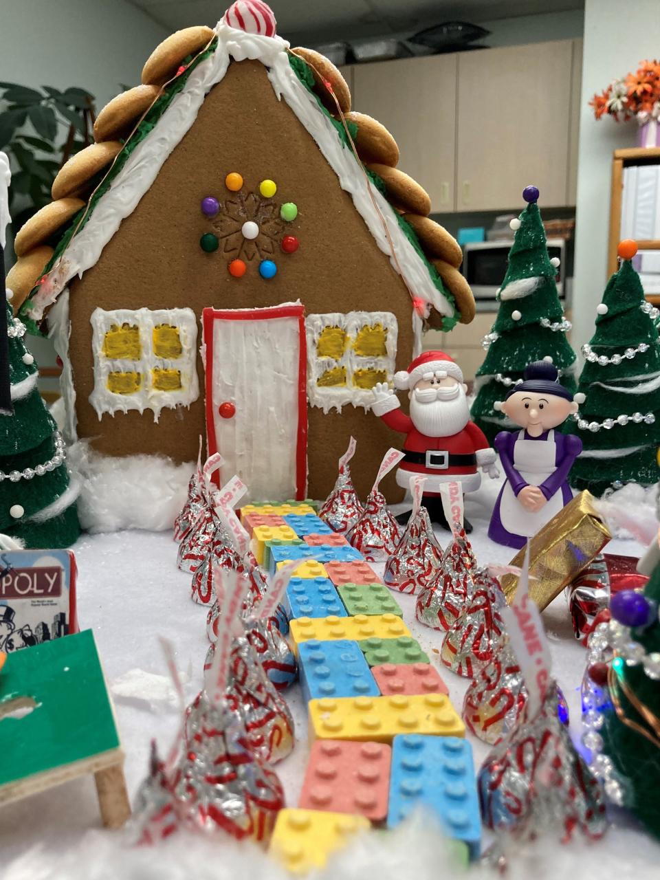 Employees in the Pueblo Housing and Citizen Services office purchased candy bricks from Taffy's, the sweets shop in Mesa Junction, to craft the walkway up to their gingerbread house display.