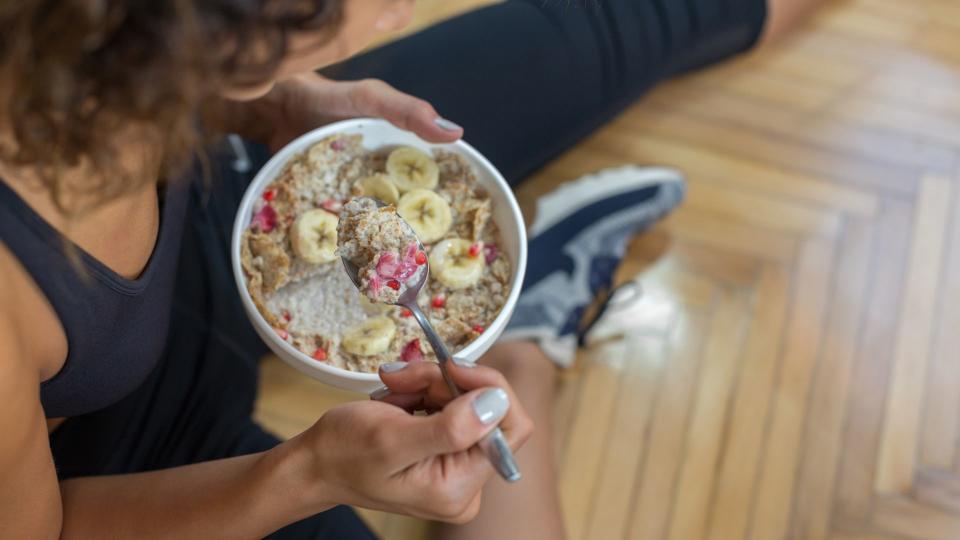 Woman eating bowl of oats