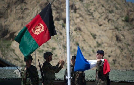 Afghan National Army soldiers raise their national flag next to the French flag during a transition ceremony at Surobi base on April 12, 2012. The French army handed the district of Surobi to the Afghan army as part of the gradual transition of the country's security to Afghan forces