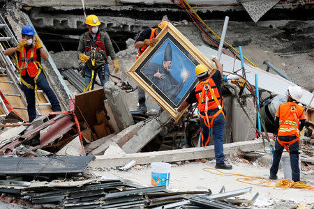 Mexican and international rescue teams remove a painting as they search for survivors in a collapsed building after an earthquake, at Roma neighborhood in Mexico City. REUTERS/Carlos Jasso