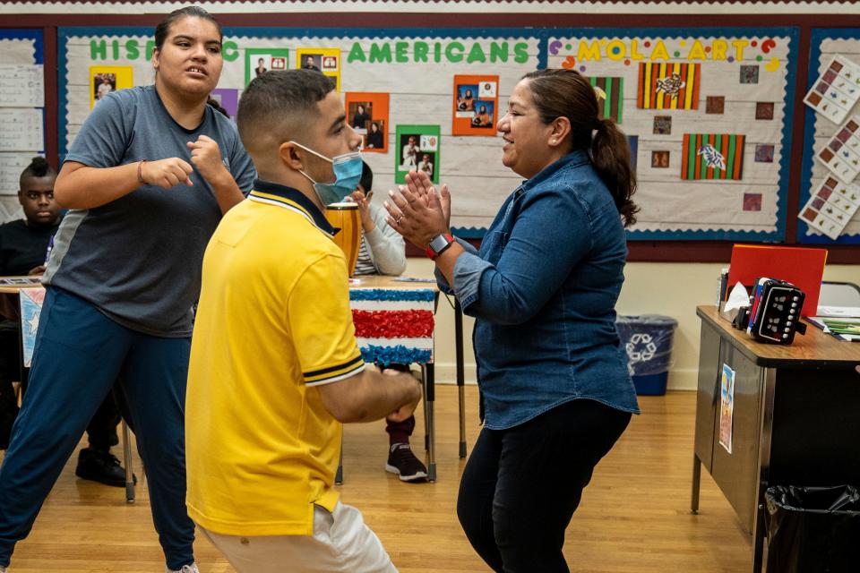 Isabel Cosme teaches Spanish to high school students at the Phoenix Center, a private special-needs school in Nutley, on Tuesday September 20, 2022. Isabel Cosme dances with Kayla (left) and Kevin (center.) 