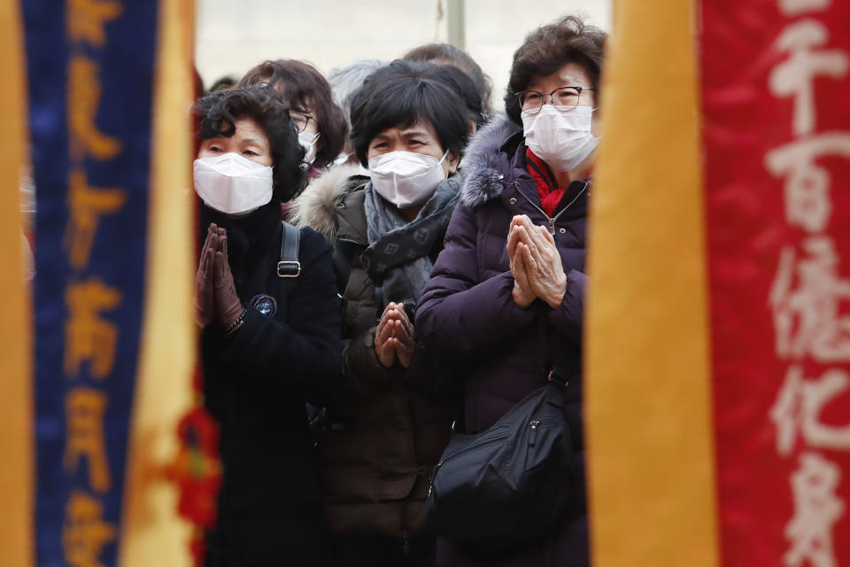 People wearing face masks pray at the Jogyesa Buddhist temple in Seoul, South Korea, Sunday, Feb. 2, 2020. This weekend, South Korea and India flew hundreds of their citizens out of Wuhan, the city at the center of an area where some 50 million people are prevented from leaving in a sweeping anti-virus effort. (AP Photo/Ahn Young-joon)