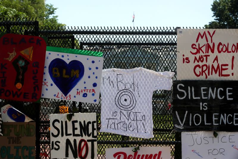 FILE PHOTO: Protest signs are affixed to the security fence around Lafayette Square at the scene where protesters clashed with police near the White House in Washington