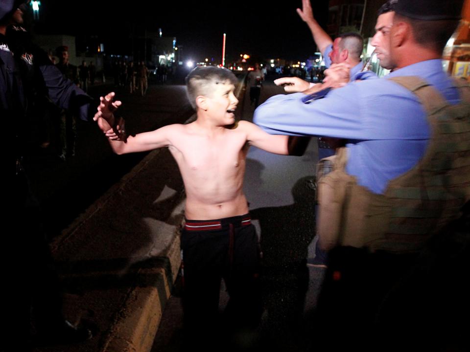 Iraqi security forces detain a boy after removing a suicide vest from him in Kirkuk, Iraq.