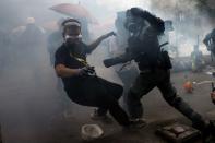 A protester is detained by riot police while attempting to leave the campus of Hong Kong Polytechnic University (PolyU) during clashes with police in Hong Kong