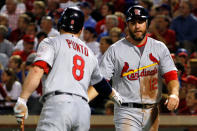 ARLINGTON, TX - OCTOBER 24: Lance Berkman #12 and Nick Punto #8 of the St. Louis Cardinals celebrate after Berkman scores on a fielder's choice in the second inning during Game Five of the MLB World Series against the Texas Rangers at Rangers Ballpark in Arlington on October 24, 2011 in Arlington, Texas. (Photo by Tom Pennington/Getty Images)