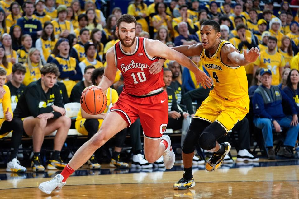 Ohio State forward Jamison Battle (10) drives on Michigan guard Nimari Burnett (4) in the first half of an NCAA college basketball game in Ann Arbor, Mich., Monday, Jan. 15, 2024. (AP Photo/Paul Sancya)