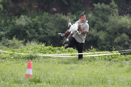 A trainee carries a drone for a examination for the license from AOPA CHINA (Aircraft Owners and Pilots Association) at LTFY drone training school on the outskirts of Beijing, China August 14, 2017. Picture taken August 14, 2017. REUTERS/Jason Lee