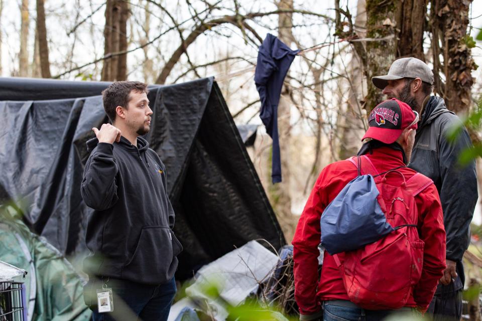 Aidan Sorrells, a peer outreach specialists, speaks with unhoused people to connect with resources for addiction treatment at Wallace Marine Park in Salem in December 2023.