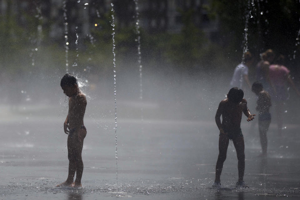 People cool off in an urban beach at Madrid Rio park in Madrid, Friday, Aug. 3, 2018. Spain's Meteorological Agency says eight provinces in the southern Andalusia region and around Madrid are under high risk because of the heat wave hitting the country starting on Wednesday. (AP Photo/Francisco Seco)