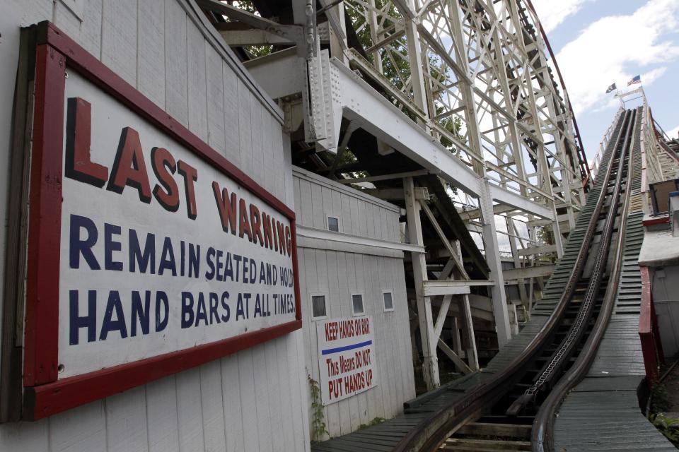 In a Tuesday, June 26, 2012 photo taken on Coney Island in New York, warning signs are posted before the first and steepest climb of the Cyclone roller coaster. The New York City landmark and international amusement icon will be feted Saturday, June 30 with a birthday party in its honor. (AP Photo/Mary Altaffer)