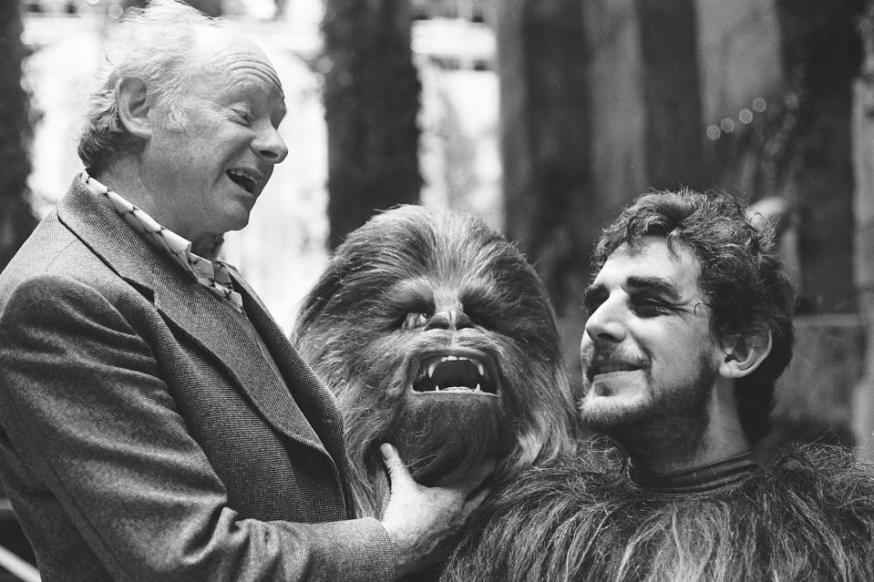 <p>Maskenbildner Stuart Freeborn übt am Set von “Eine neue Hoffnung” mit Peter Mayhew den Schrei von Chewbacca. Mayhew spielte den haarigen Copiloten und Freund von Han Solo in insgesamt fünf Filmen – in allen drei Teilen der ersten Trilogie sowie in “Star Wars: Episode III – Die Rache der Sith” und “Star Wars: Das Erwachen der Macht” (Bild: ddp/INTERTOPICS/PictureLux) </p>